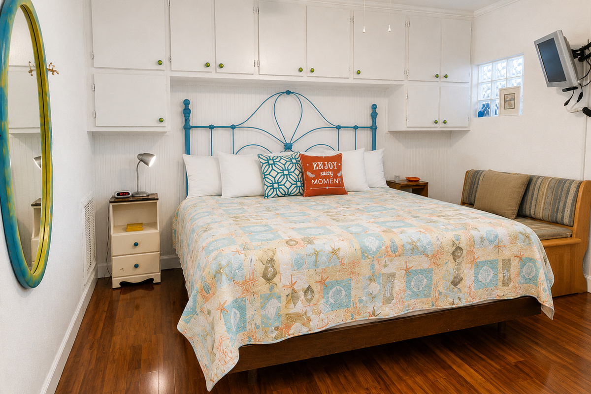 From the doorway into the bedroom - Huge king bed,  lots of storage, wall-mounted TV.  (Bathroom located to the left before the bedroom doorway.)