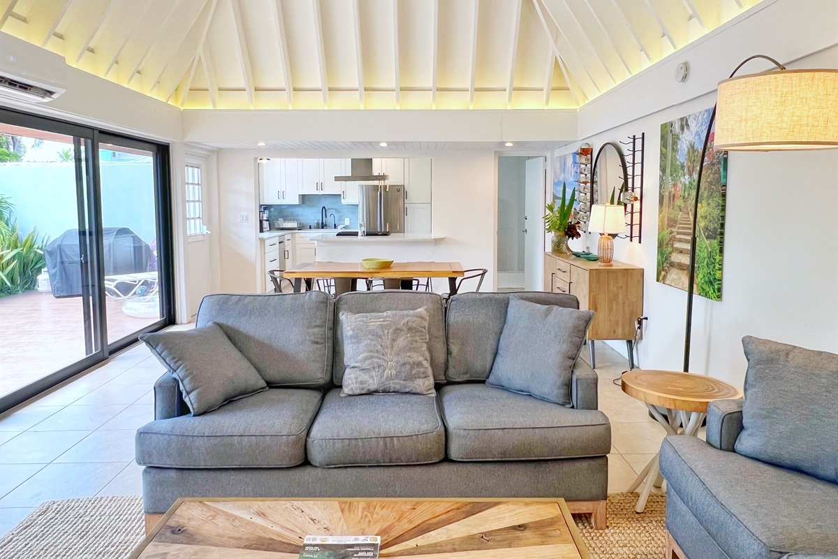 Stylish wooden tables and bright coastal d&eacute;cor complete this inviting living room.