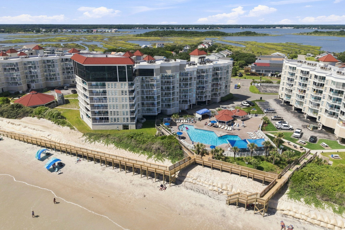 Resort-style amenities right on the beach, featuring an outdoor pool, lounge deck, and direct beach access.
