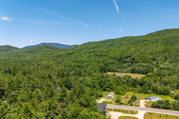 Escape to a scenic setting surrounded by rolling mountains, greenery, and open skies.