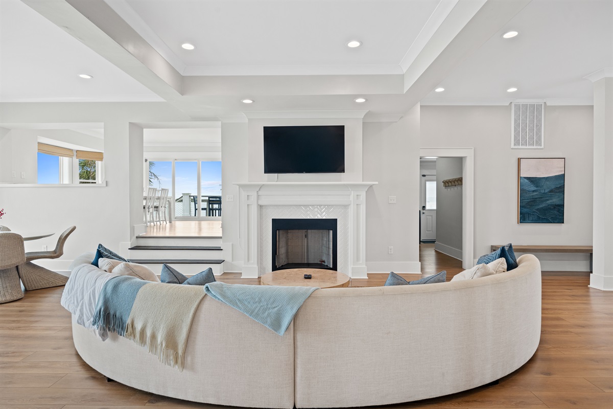 Gather around the oversized curved sectional for movie nights by the fireplace and mounted Smart TV