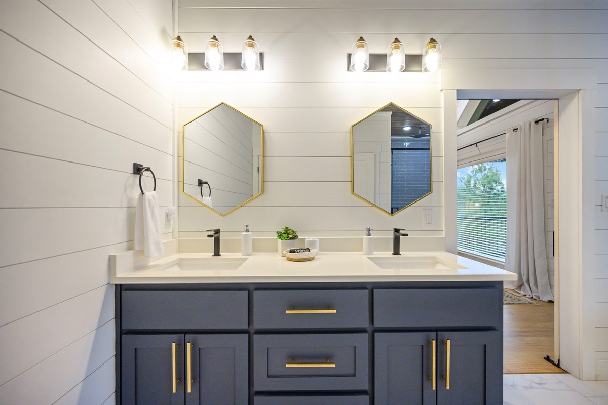 Ensuite bath with double sinks, designer lighting, and easy access to the primary suite.