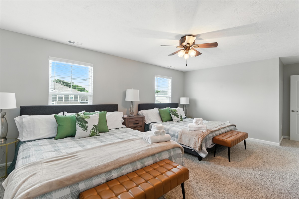 Stylish master suite with two king beds nightstand and plenty of storage