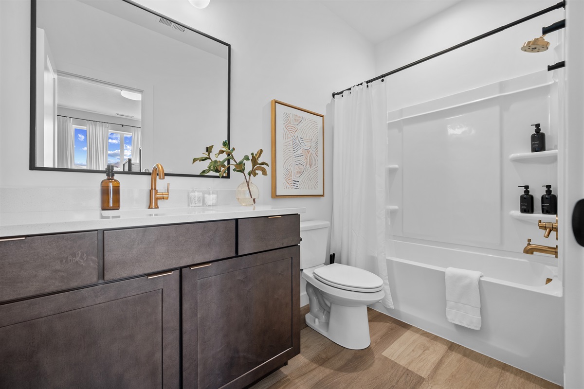 Modern ensuite bathroom with sleek vanity and a full tub/shower.