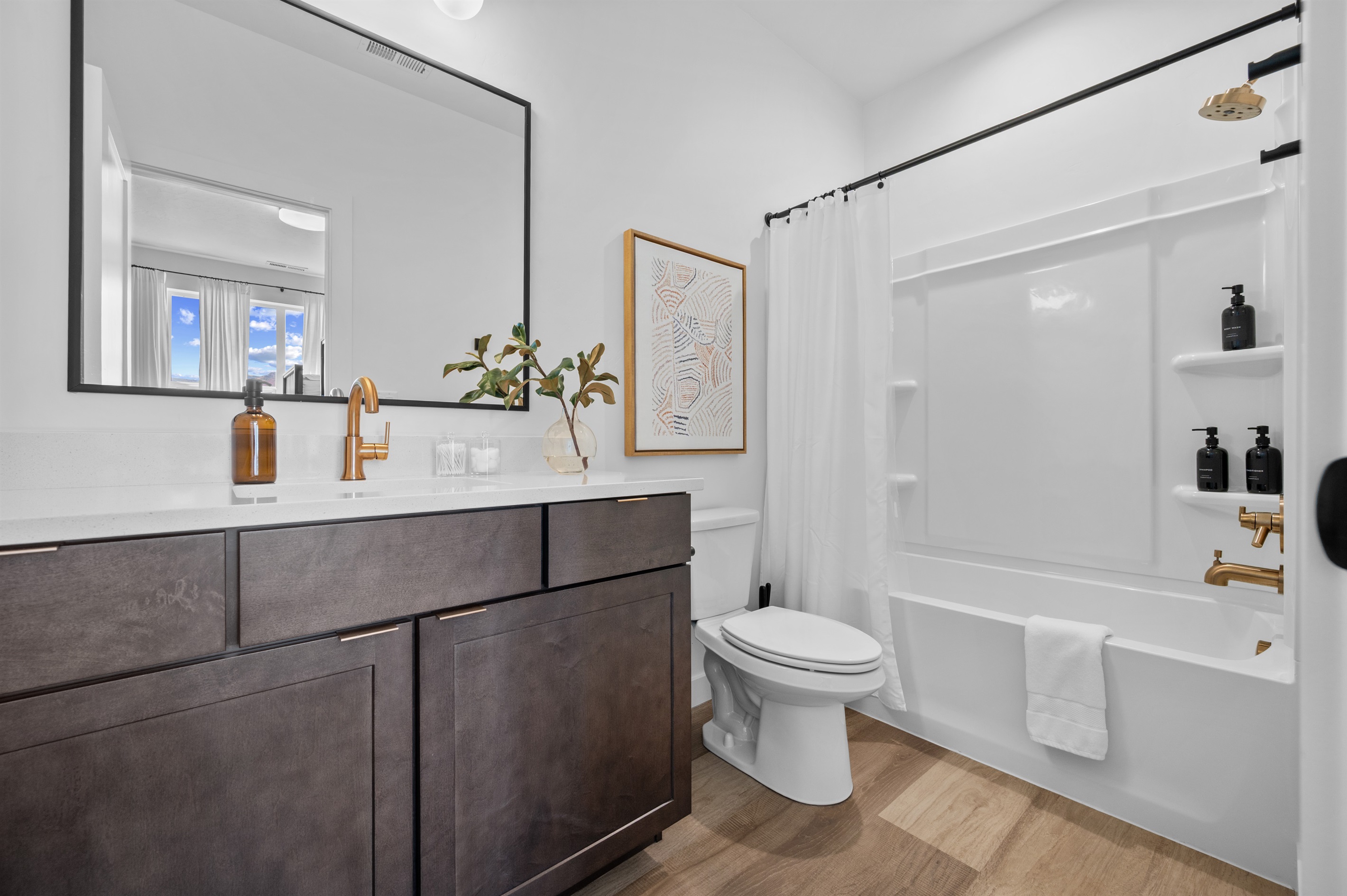 Modern ensuite bathroom with sleek vanity and a full tub/shower.