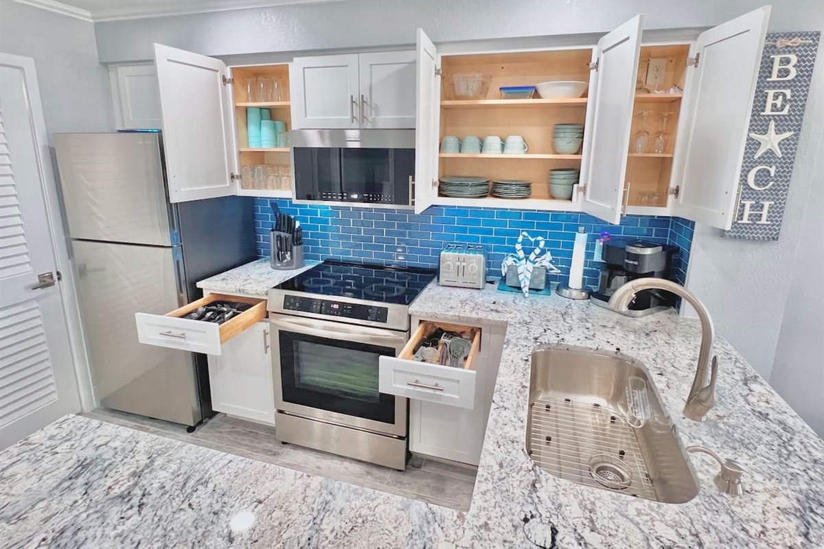 Very nice stainless steel appliances and cabinet space loaded with plates, bowls, cups, silverware, etc. 