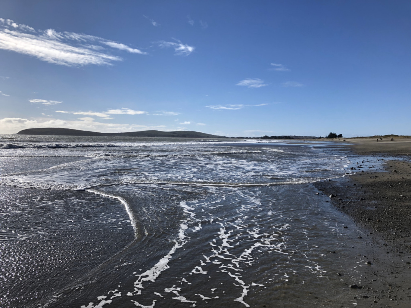 Shallow waves spreading across wet sand