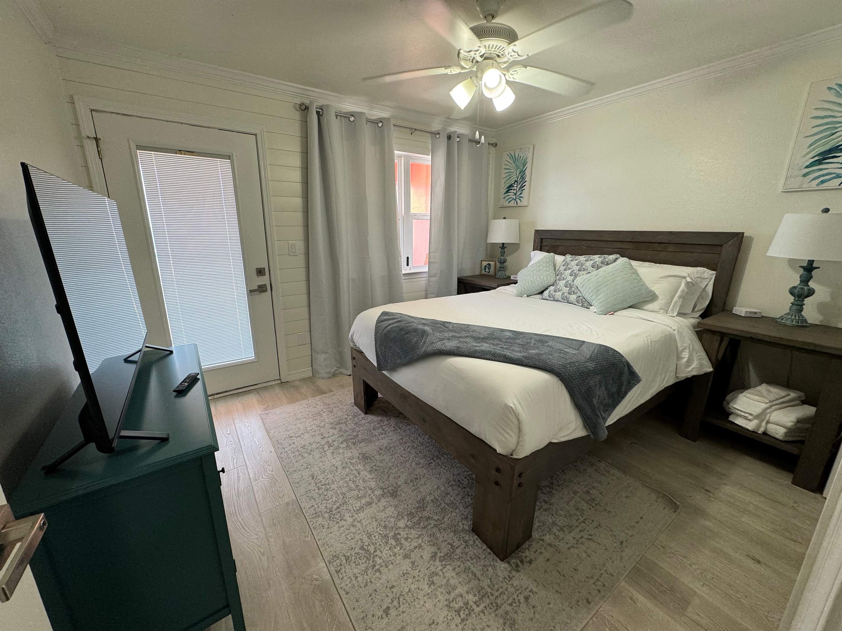 Second bedroom with queen bed and smart tv, balcony access