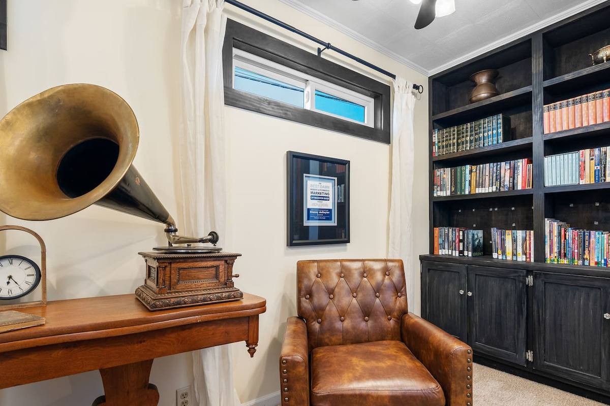Library with leather chairs, stocked bookshelves, and a vintage record player.