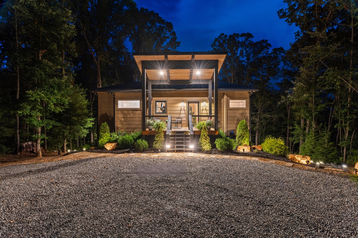 At night, the lodge glows warmly, offering a magical ambiance in the heart of the peaceful forest.