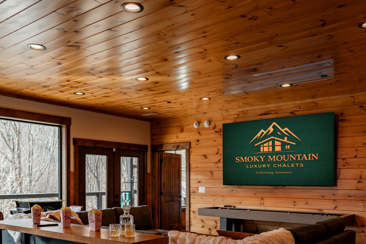 Perfect for game day, movie nights, or family fun, featuring a 100” TV, cozy sectional seating, and bar stools so everyone has a great view.