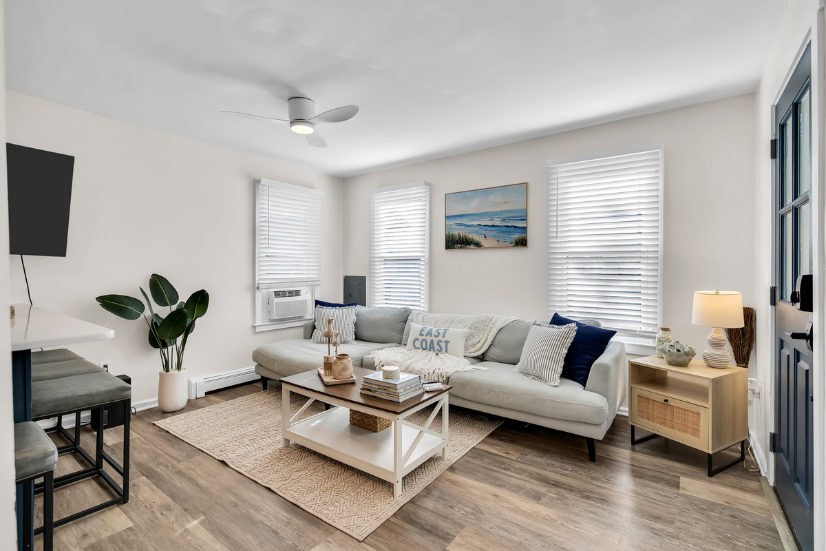 Drop your bags and exhale. You will spread out on the sectional here, salt air drifting through the windows, the whole apartment open and bright around you.