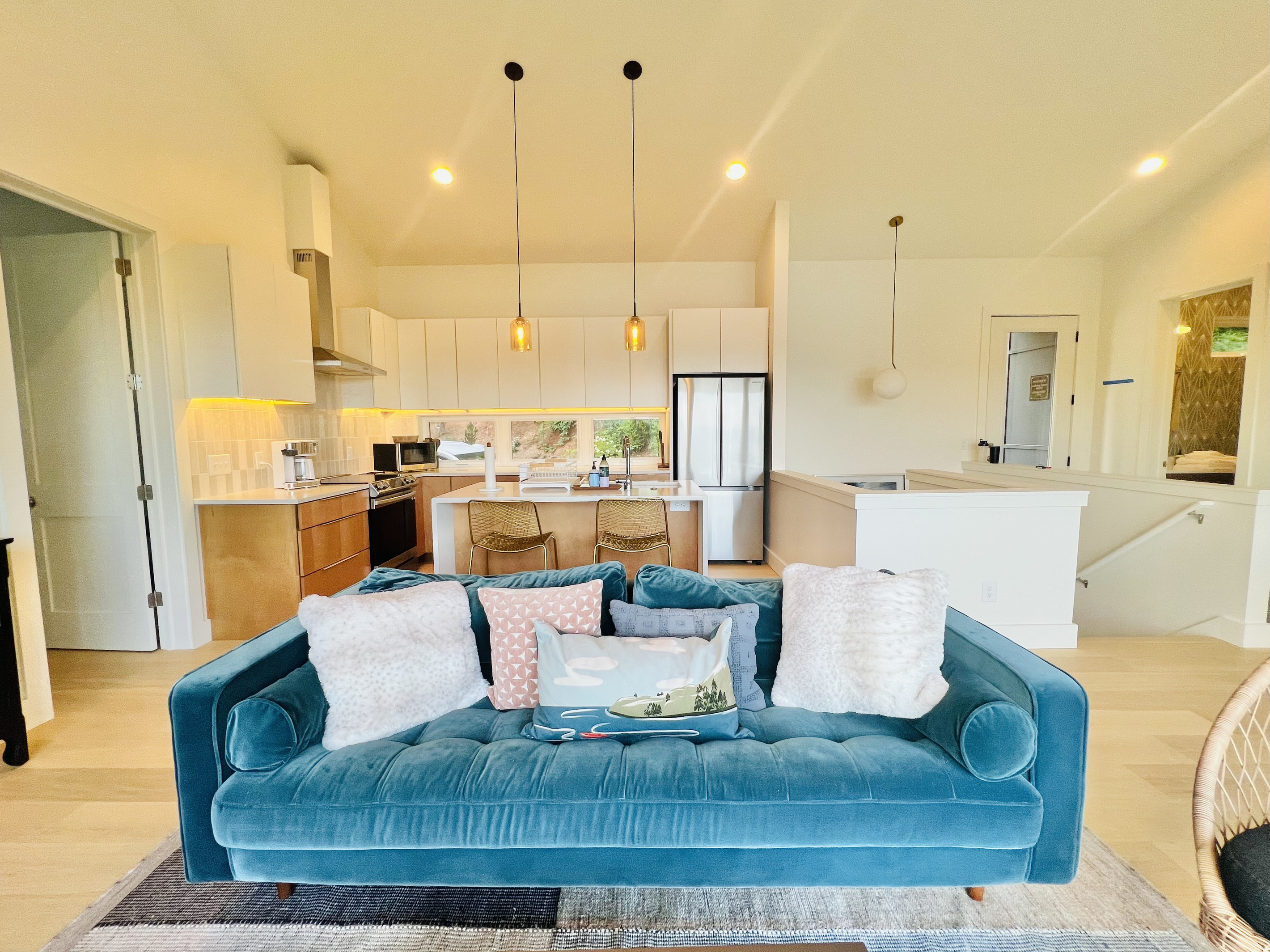 Relax and unwind. The main-level living room offers comfortable seating, a Smart TV, a wood-burning stove, and direct access to the covered deck. Large windows and glass doors keep the lake and mountain views front and center.