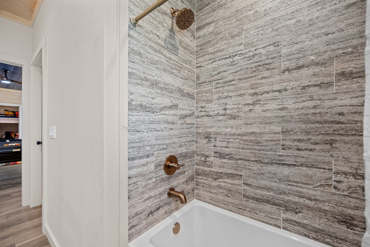 Shower-tub combo with modern stone tile design.