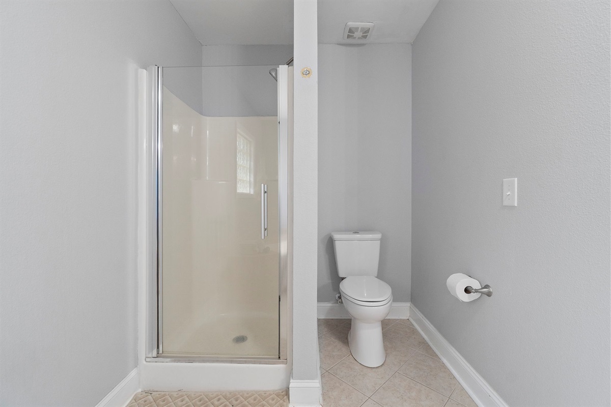 In this compact bathroom zone with a walk-in shower and toilet. Ideal for guests or quick morning routines, this section complements the main bathroom's serene aesthetic while maintaining privacy and ease of use.