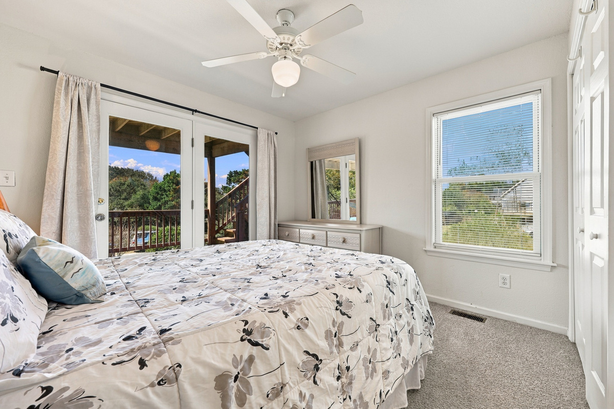 Wake up and walk right out to the deck from this bright bedroom.