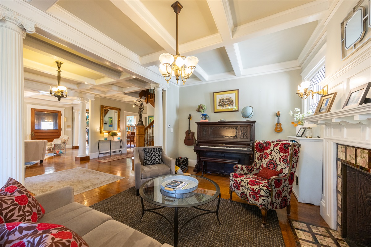 Second living room with piano and cozy seating — ideal for relaxing or playing music.