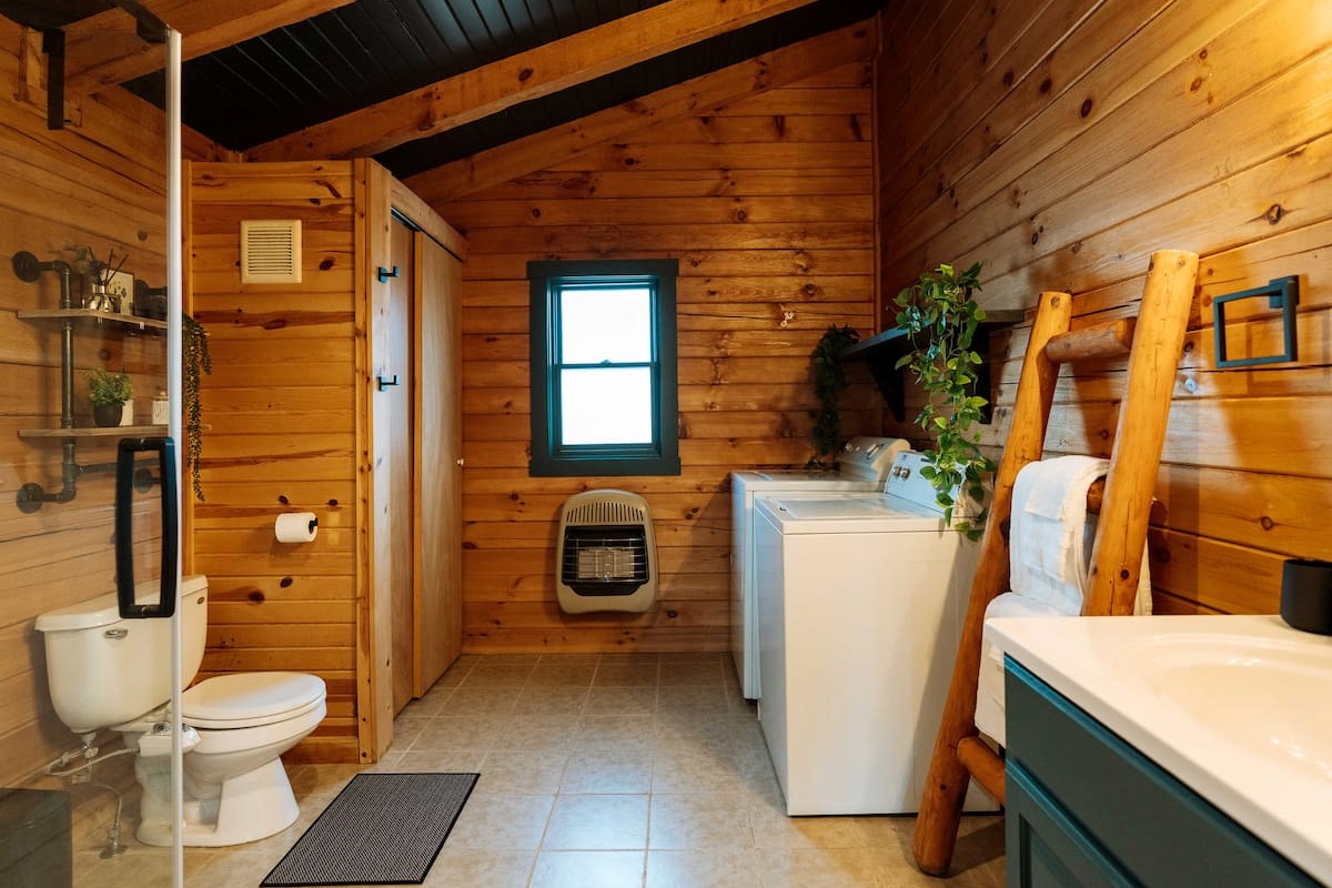 A spacious, multi-functional washroom featuring a modern glass shower and convenient in-suite laundry.