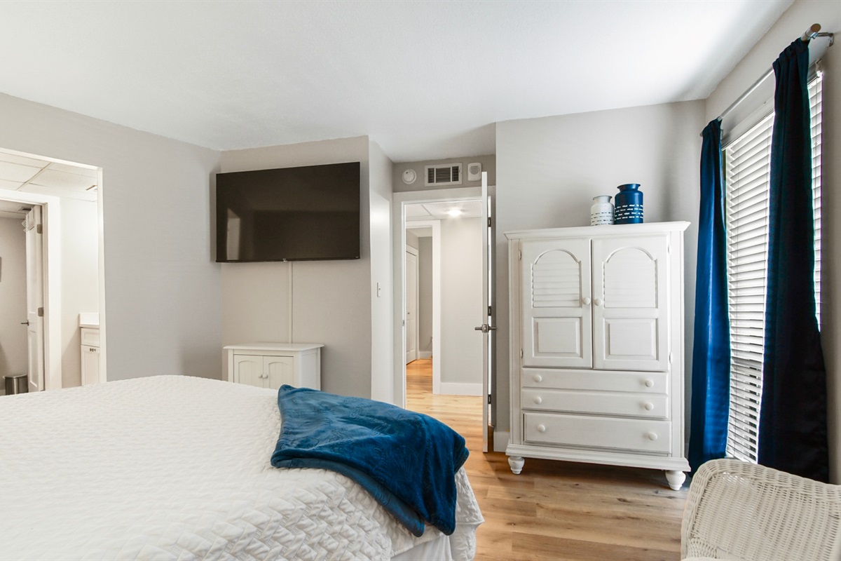 Main bedroom with king bed, ensuite bathroom, smart TV and clothing storage
