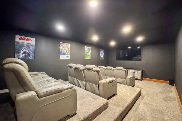 Theater room with a smart TV and six power recline seats.