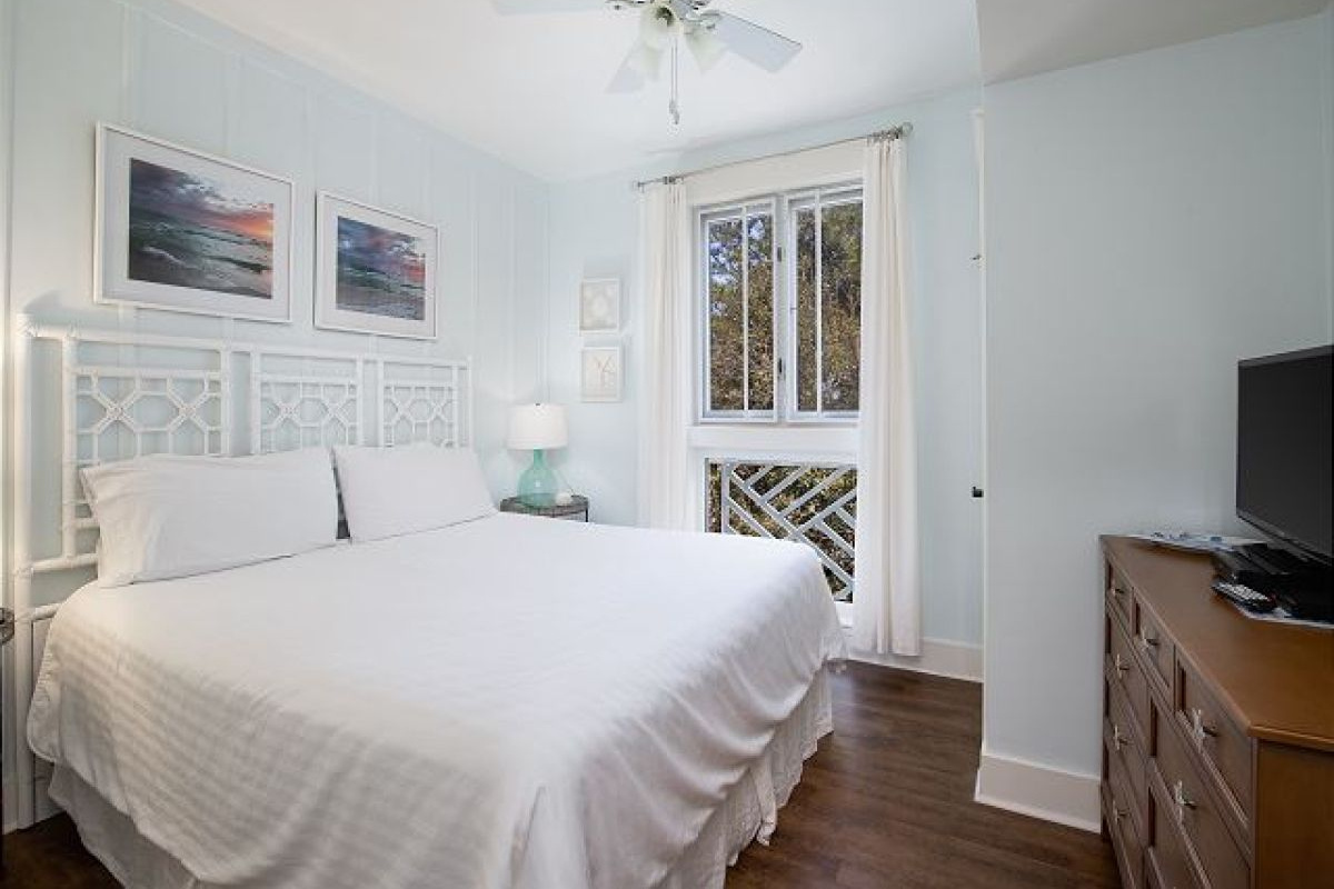 King master bedroom with HDTV, dresser, ceiling fan and a window with resort garden views