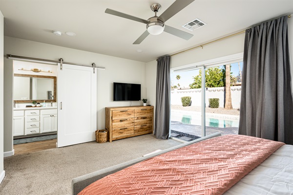 A contemporary barn door opens onto the en suite bathroom from the main bedroom.