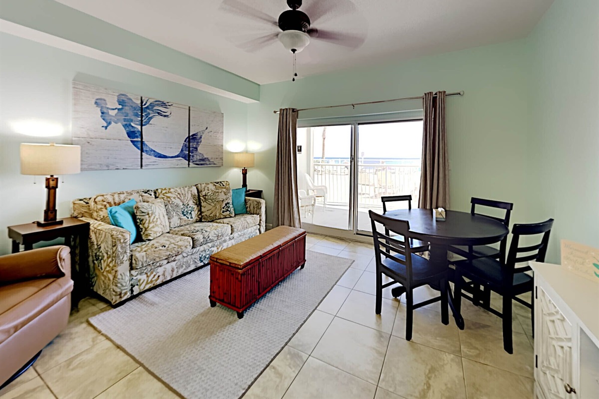 Living room with sleeper sofa, smart TV, recliner, ceiling fan and balcony access