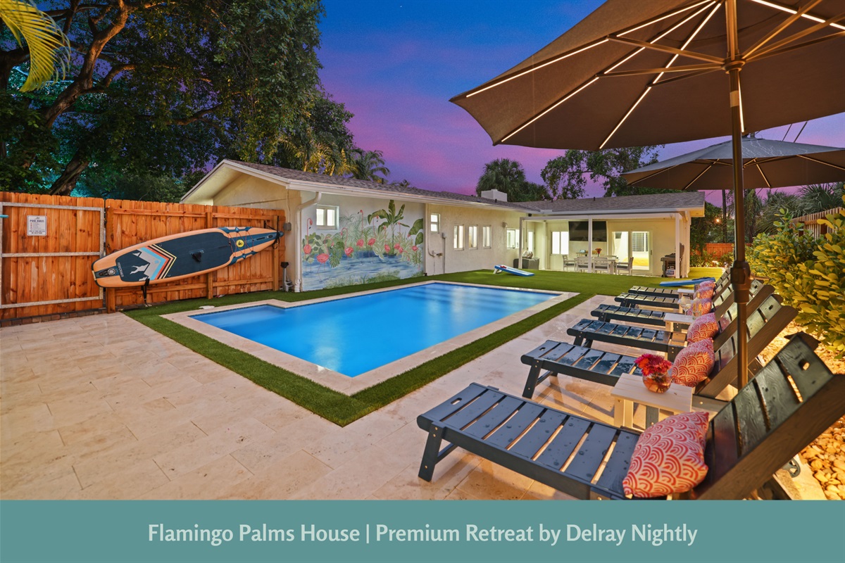 Unwind in this tropical outdoor retreat, featuring a sparkling private pool surrounded by lush greenery and stylish lounge chairs.