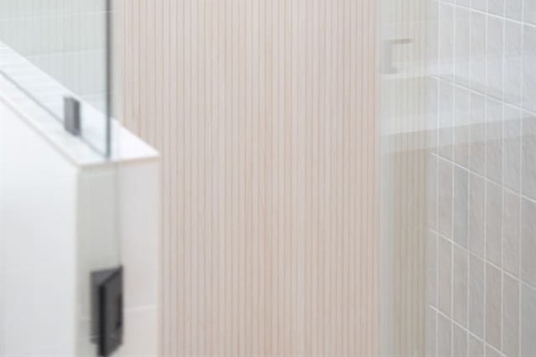 Walk-in shower with rainfall showerhead and clean tile finishes.