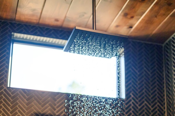 Semi-private bathroom for those staying in the Bunk room. This bathroom features modern teak finishes, stunning modern design, and an oversized rain shower with dual shower heads. 