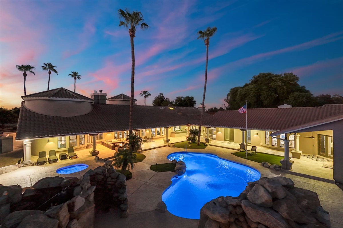 Experience ultimate relaxation with this luminous pool framed by swaying palms and luxurious patio spaces.

