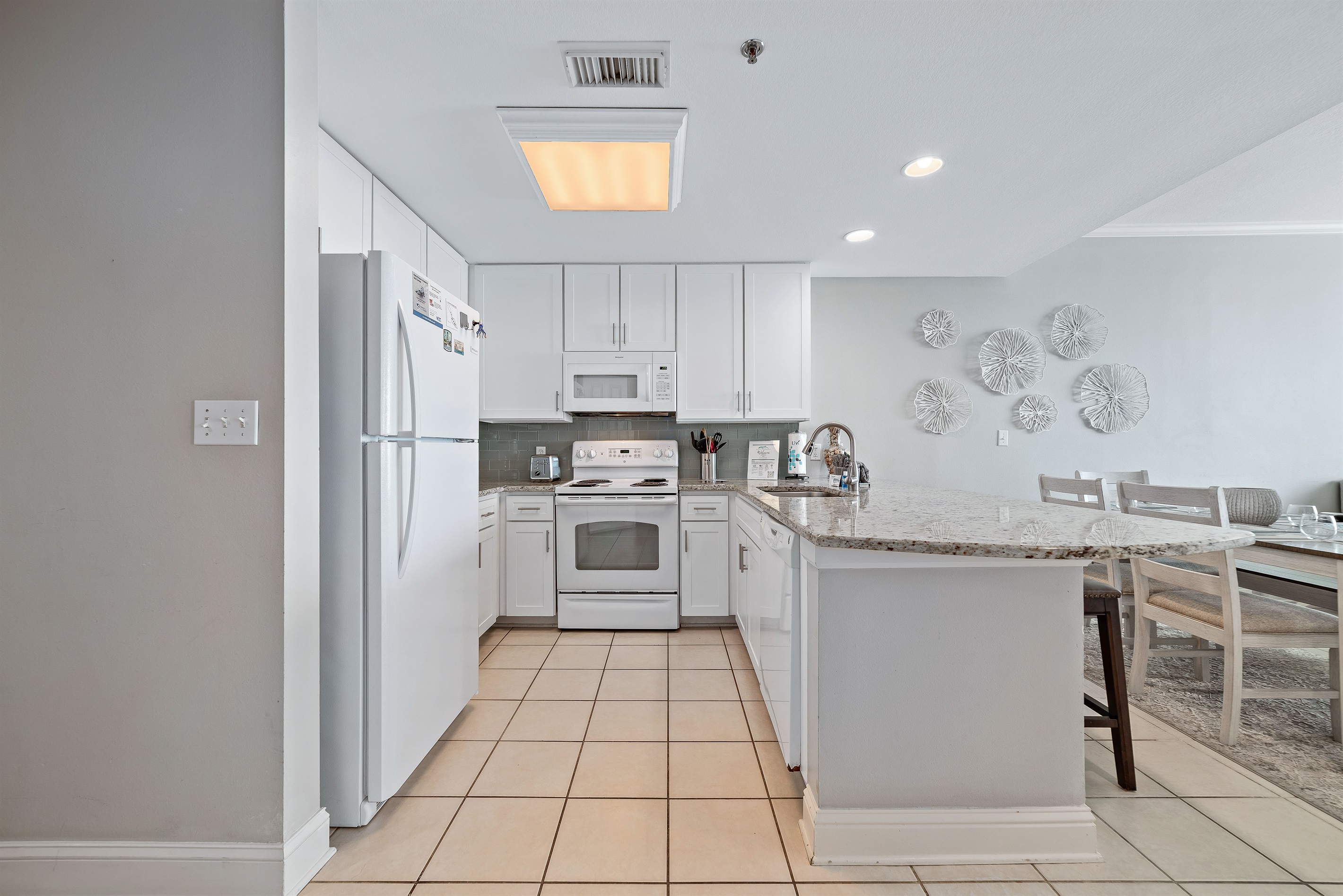 This fully functional kitchen boasts stainless steel appliances, sleek countertops, a decorative backsplash, and ample cabinet storage, ideal for everyday cooking and entertaining.
