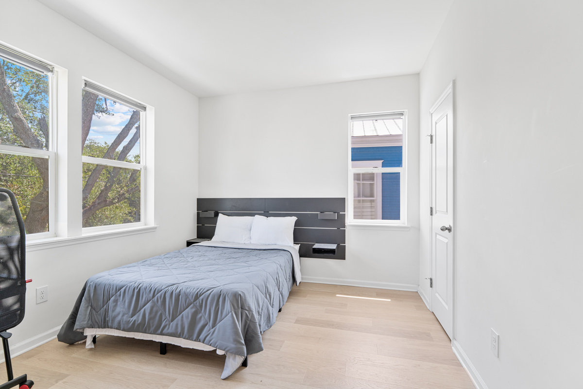 Morning light, oak branches at the window, and a bed made for sleeping in. This upstairs room is where the teenagers disappear to, and where whoever claims it first will linger long past breakfast on a slow morning.