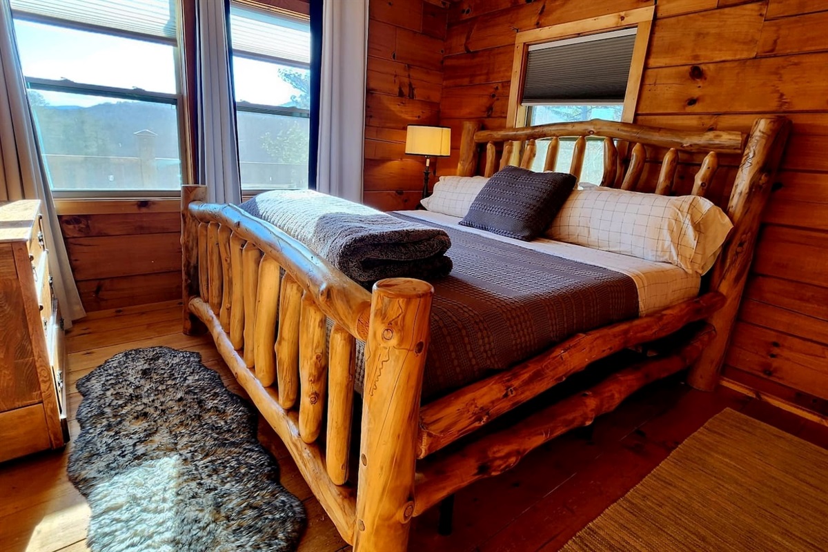 Main floor Master bedroom 1 with beautiful views. Fall asleep to the sound of the river!