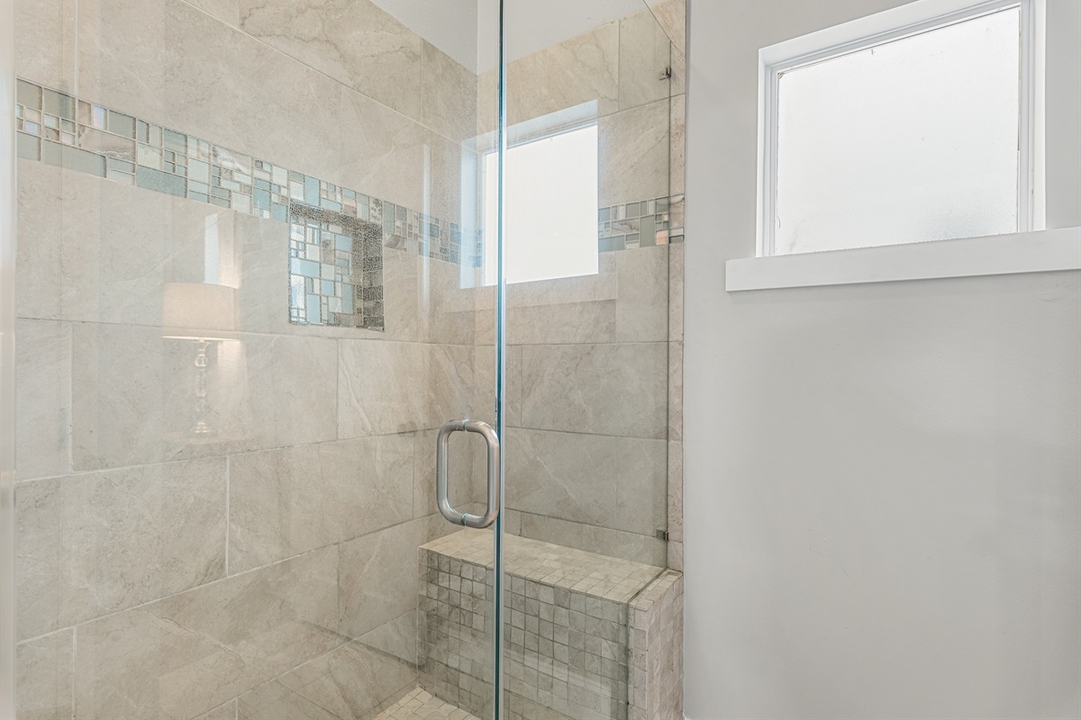 Master bathroom walk‑in shower with glass enclosure and tile detail