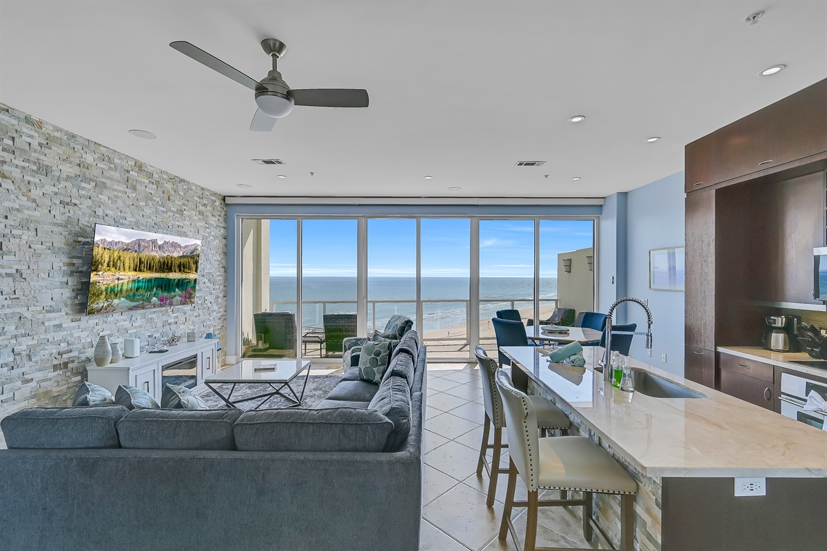 75 inch smart TV, sectional, open kitchen, kitchen island, bar, dining area, beach view