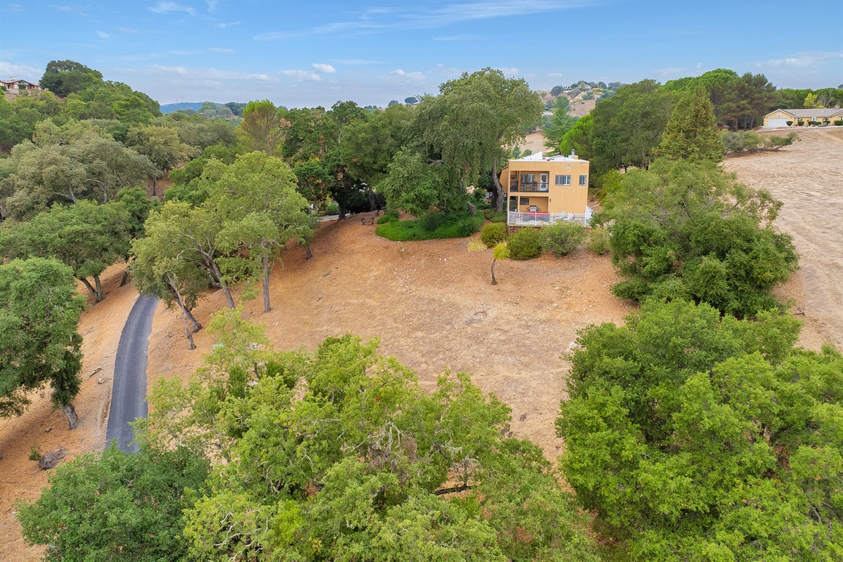The home is nestled within a vast canopy of mature oak trees, offering absolute tranquillity and panoramic vistas of the distant valley and hills.