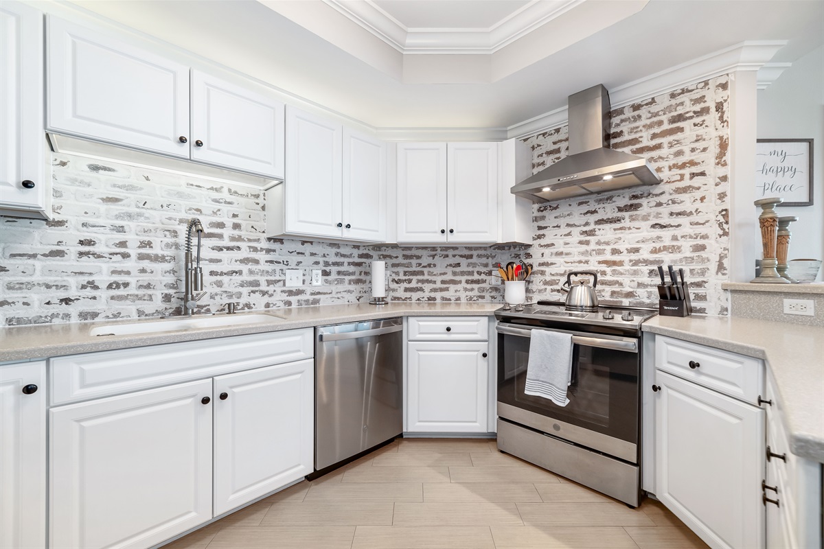 Updated kitchen with stainless steel appliances, quartz countertops, and a contemporary backsplash, offering both functionality and aesthetic appeal.