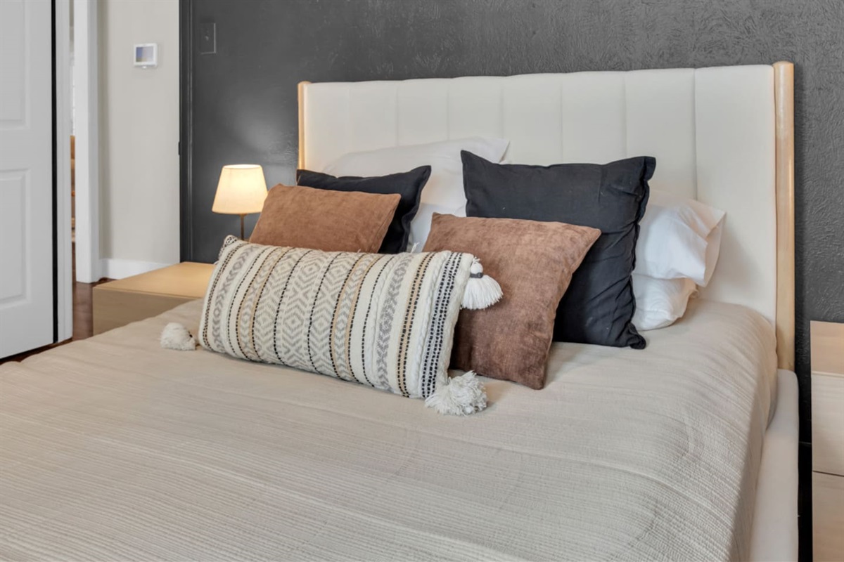 Queen bedroom designed for comfort, featuring a cozy bed, room-darkening shades, and a ceiling fan for a restful night’s sleep.
