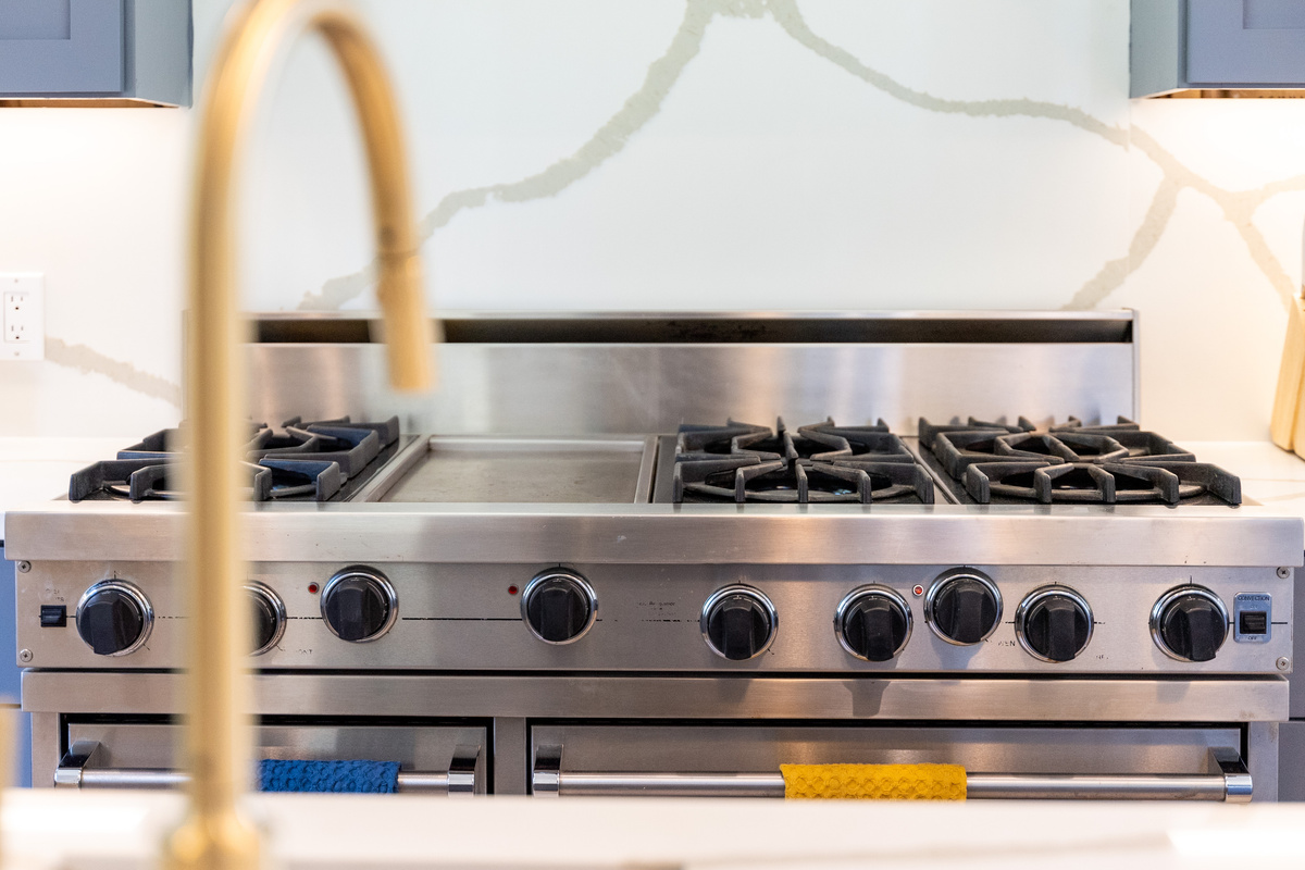 Commercial-style range with brass fixtures — a home cook's dream setup.