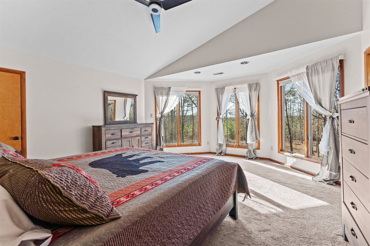 Master Suite: Sun-drenched windows frame serene forest views in this inviting, spacious retreat!