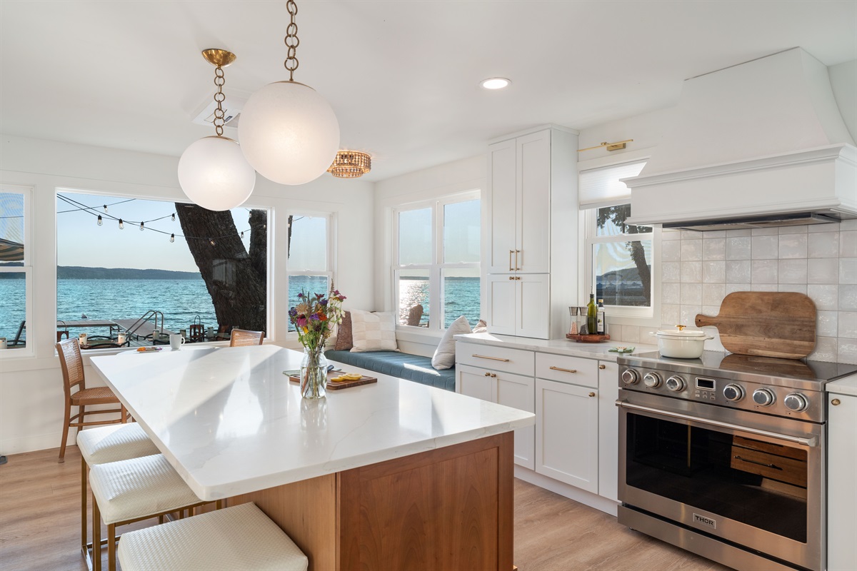 The stunning kitchen is a chef's dream and perfect for gathering.  Enjoy the 36" chef's stove, the 7' island, a stocked coffee bar, or the 7' window seat perfect for relaxing and taking in the view. And you won't miss any of the game on the SmartTV!