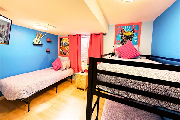 Bunk Up in Style – Our Bunk Room 1 sleeps 3 guests, offering a twin bed + twin bunk beds and a 55-inch TV for movie nights.