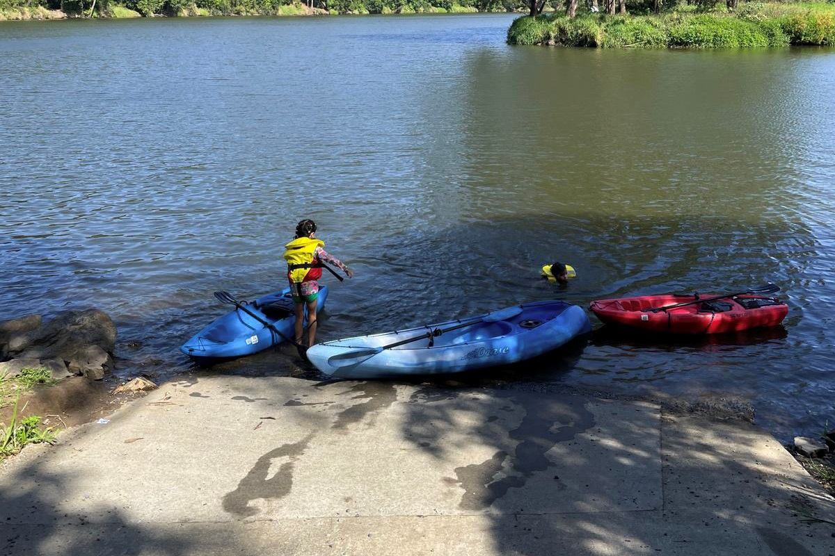 Kayaks beside the water give Summers Green View Retreat a standout outdoor feature, connecting the home with nearby lake access.