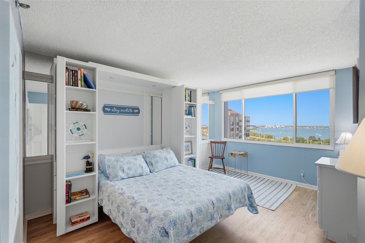 The second bedroom offers a relaxing space featuring a comfortable Murphy bed, stunning bay views, and plenty of closet storage. It also includes a dedicated workstation, making it ideal for working professionals or guests needing a quiet space.