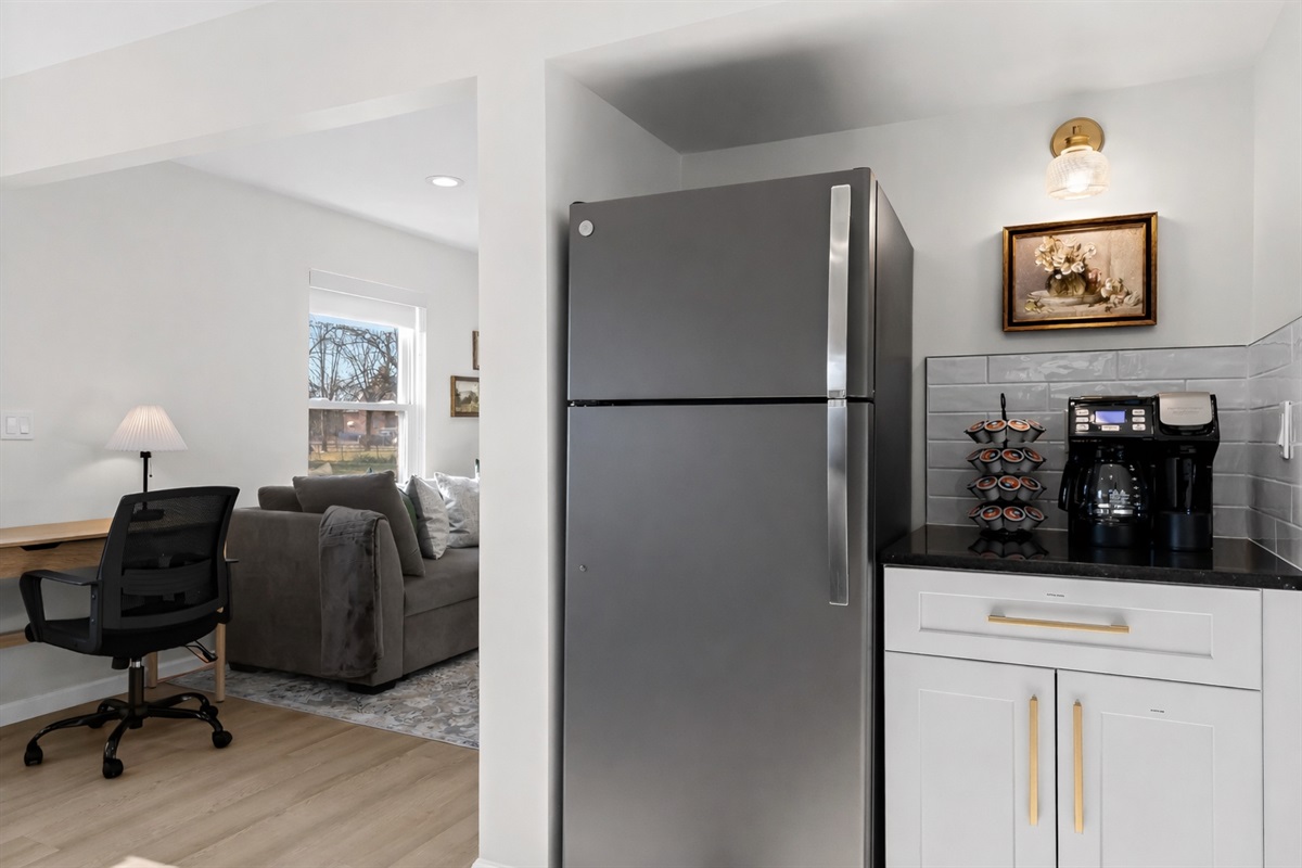 Well-appointed kitchen corner with full-size fridge, coffee station, and easy access to the living and work areas—perfect for mornings and everyday convenience.