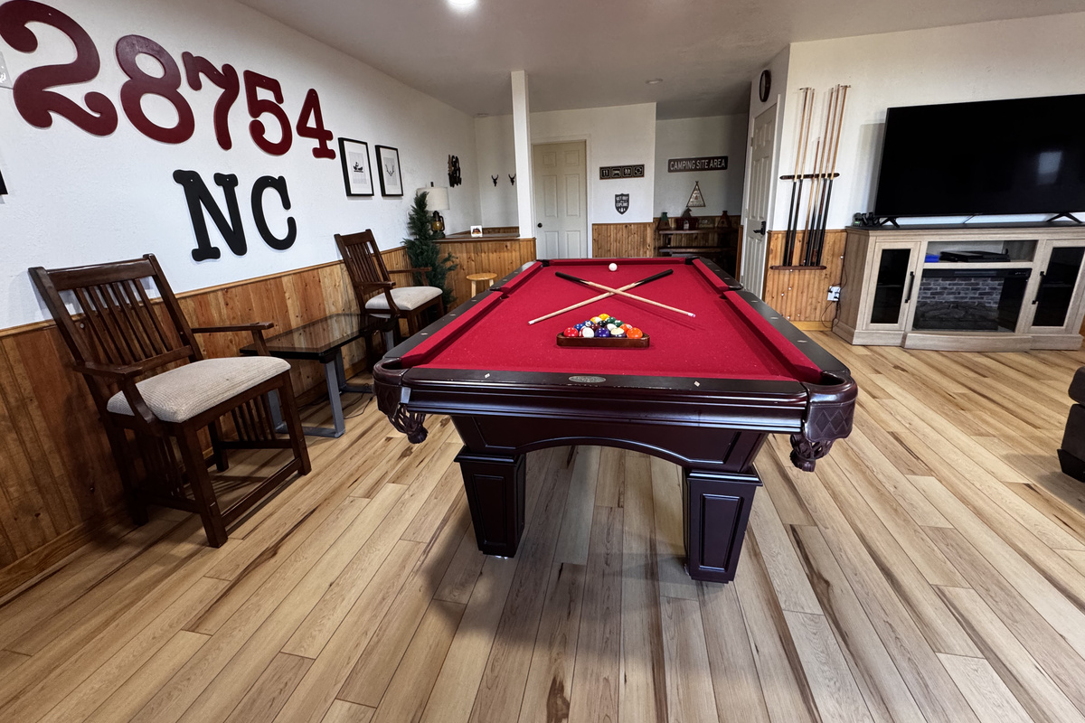 Another view of the spacious game room, with a pool table, TV and seating for your group.