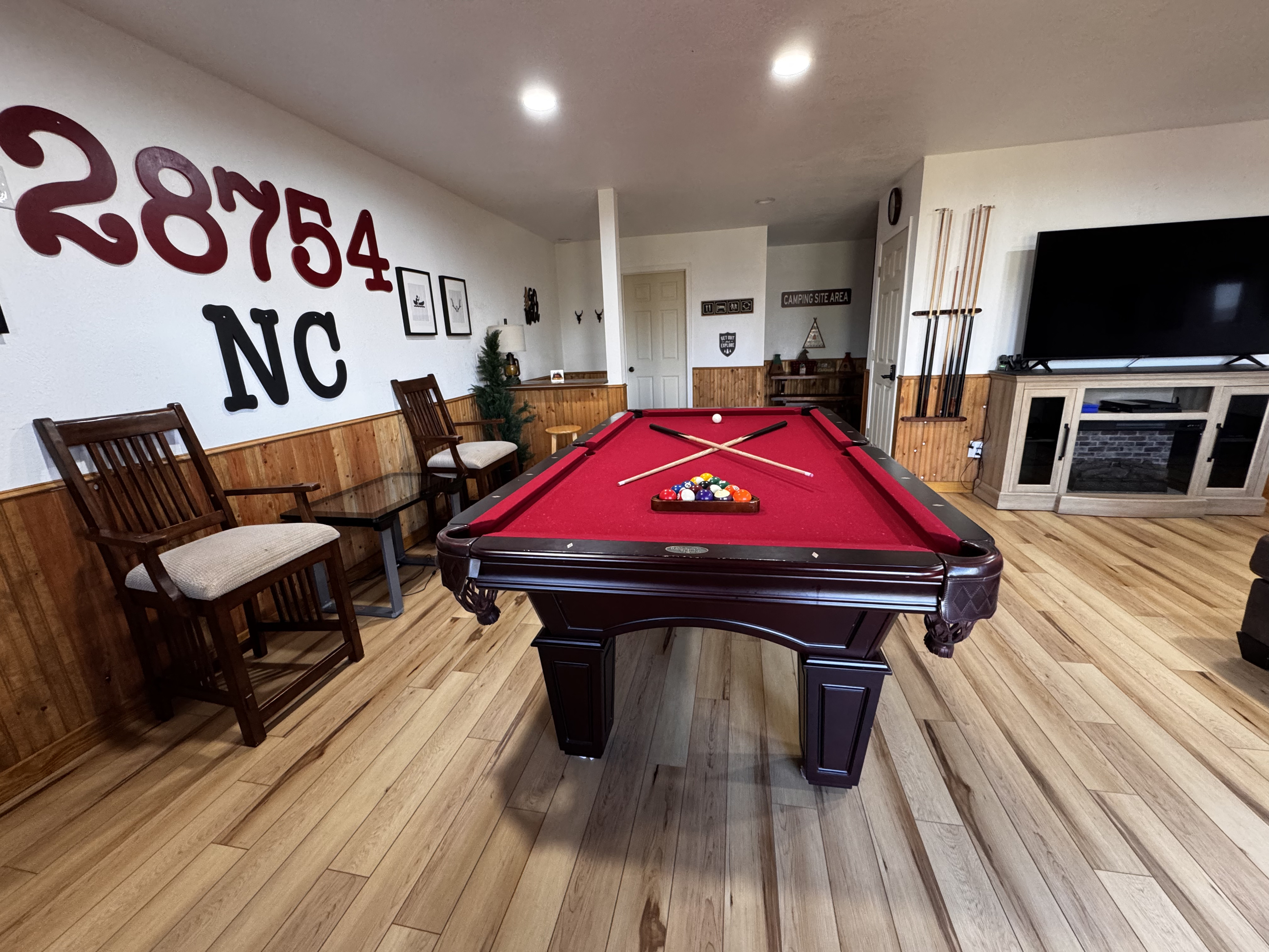Another view of the spacious game room, with a pool table, TV and seating for your group.