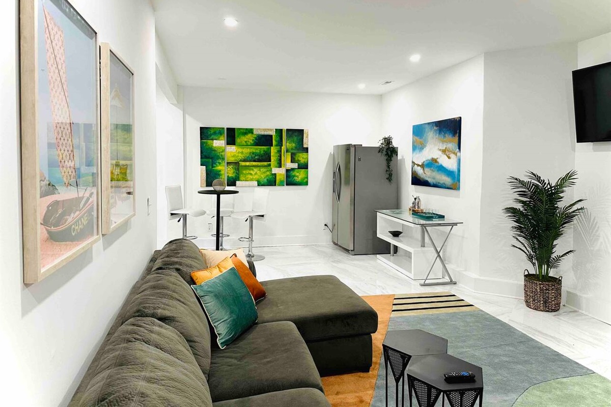 Take in the stunning view of this modern living room, complete with sleek grey sofas and a beautiful dining area.