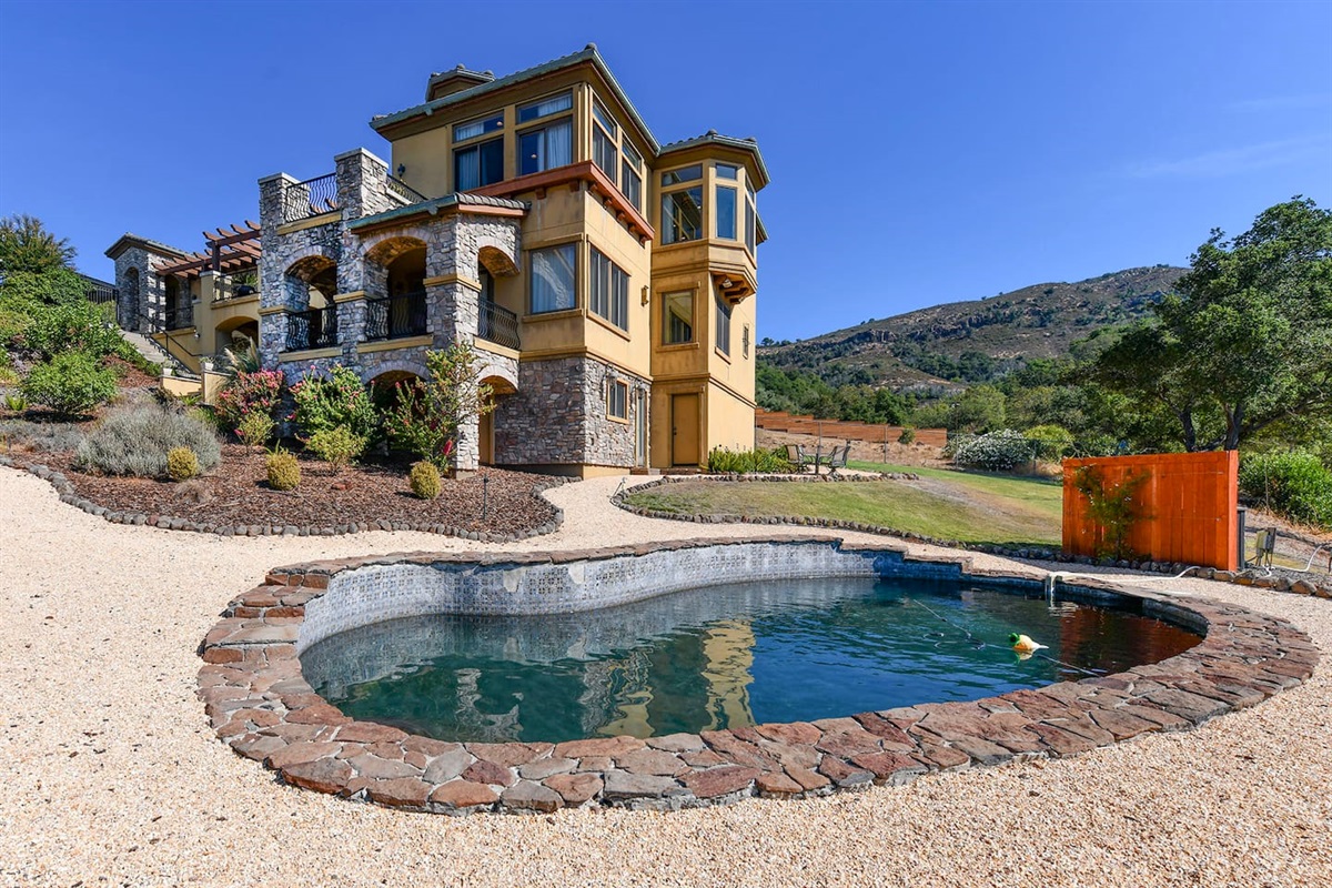 Backyard with pool and lounge area.